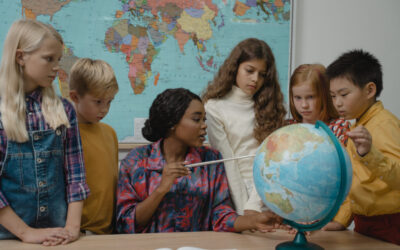 Girl in white long sleeve shirt holding blue and white globe